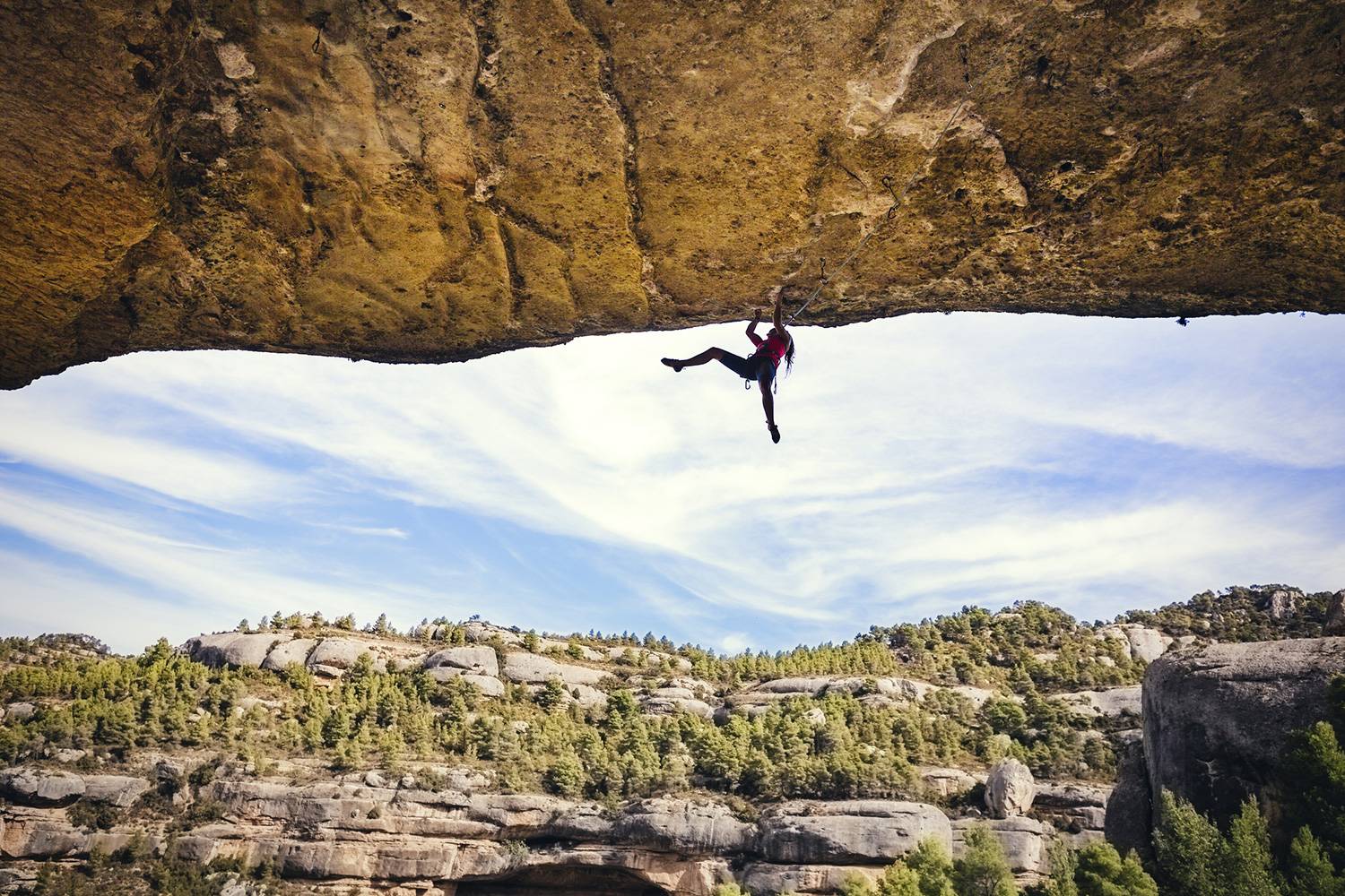 woman rock climber hanging from cliff