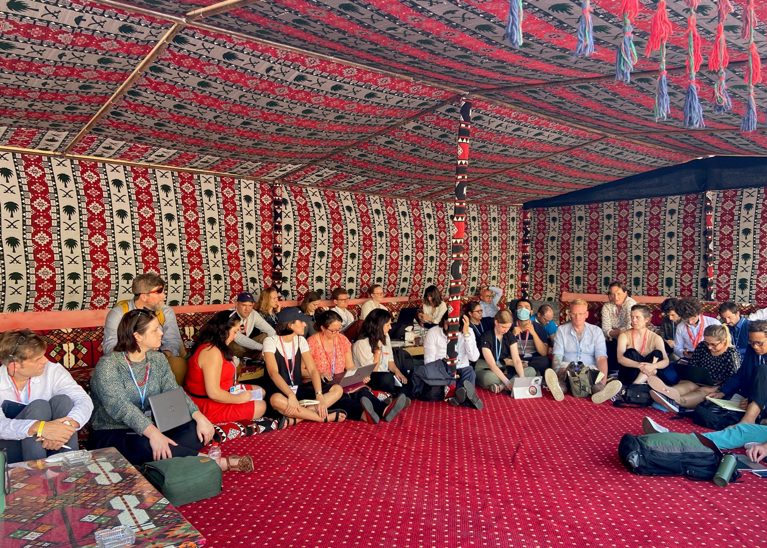 people sitting in a circle in a room filled with patterned tapestries